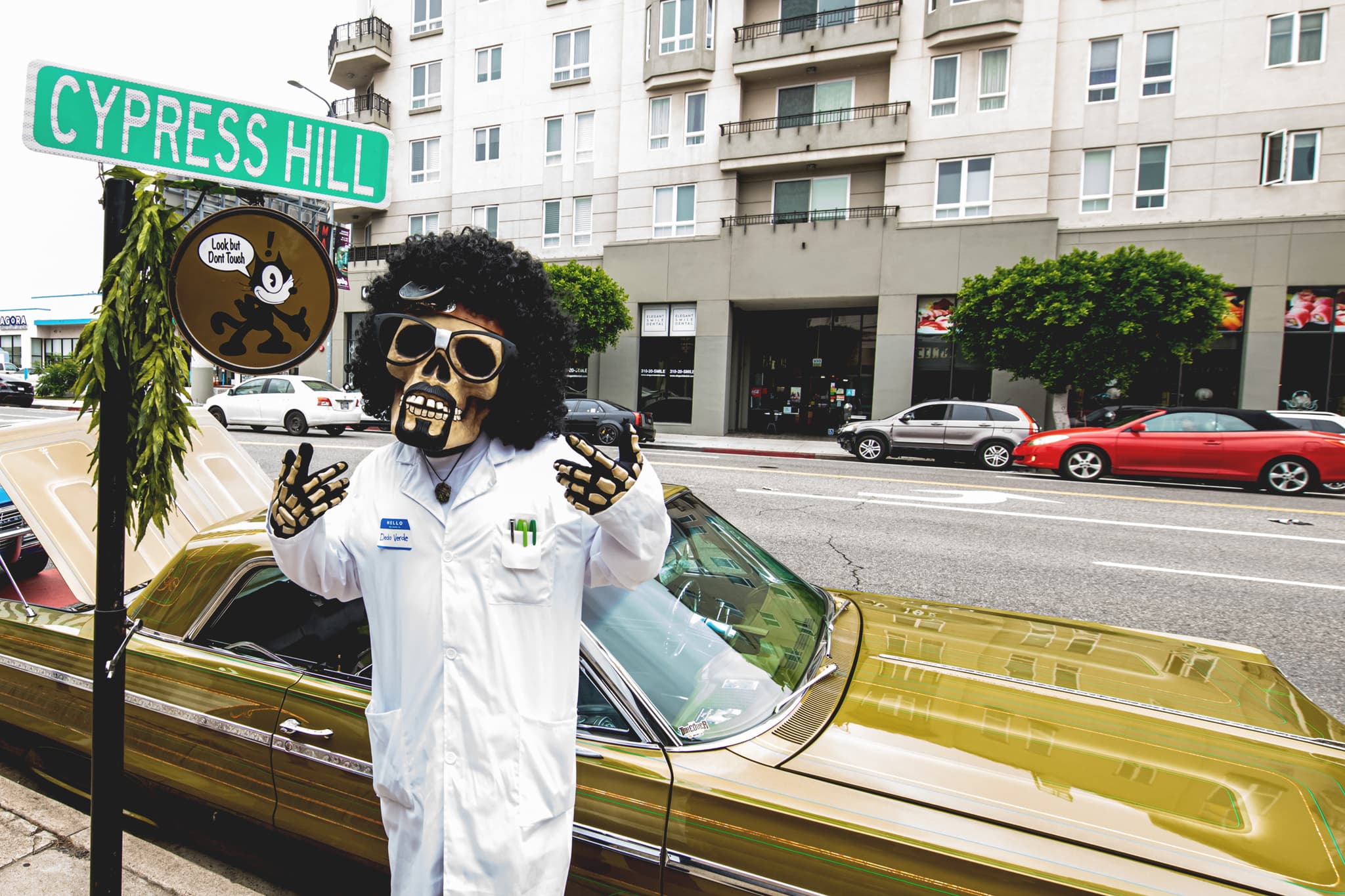 Dr. Greenthumb mascot at Cypress Hill with gold lowrider