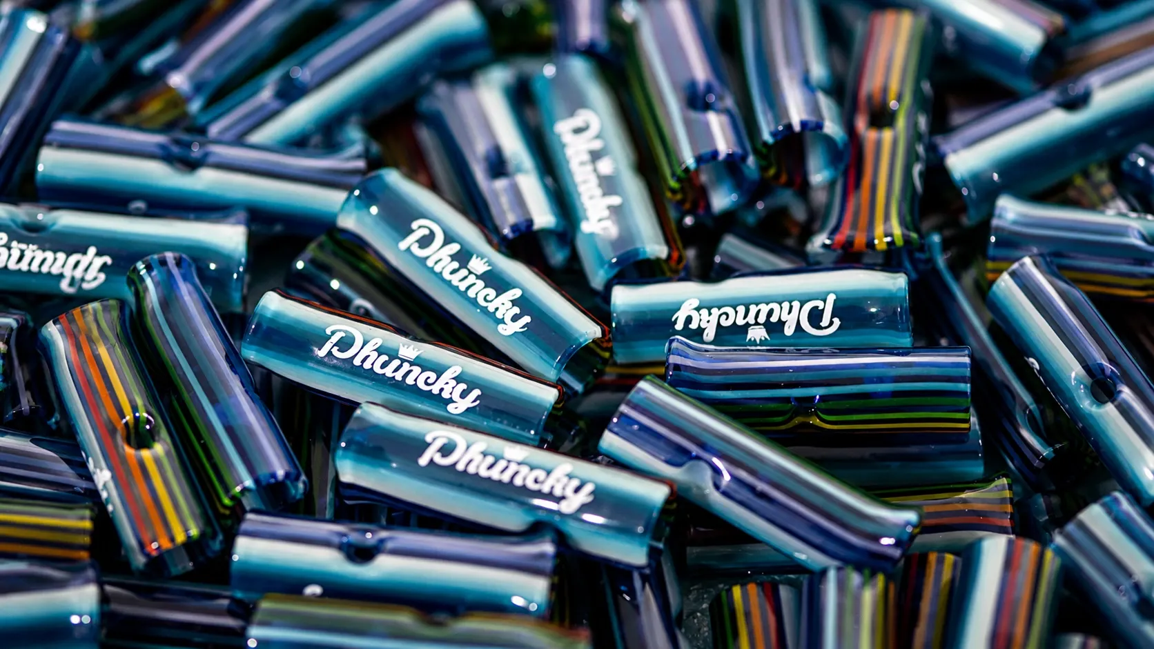 A pile of Phuncky Feel Tips glass joint tips in striped borosilicate glass